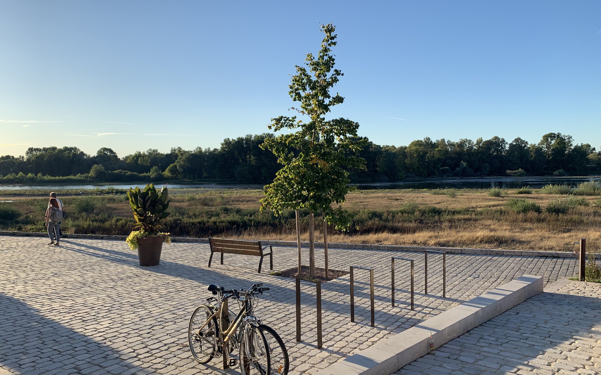 Paseo empedrado junto al río al atardecer en una etapa del Camino